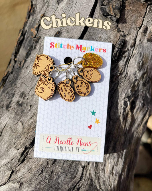 A set of six chicken themed stitch markers including a nest and golden egg